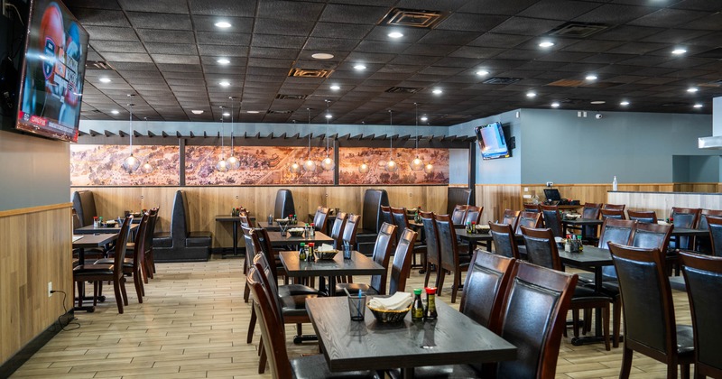 Interior, dining area, tables for four with leather padded chairs, tile flooring, TV