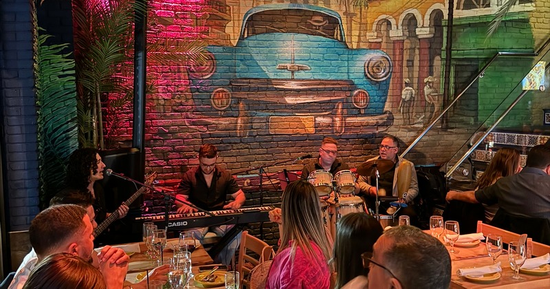 Interior, seating area, guests enjoying listening to the band playing music in the back