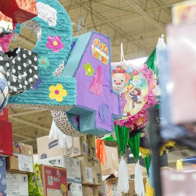Several colorful pinatas hanging up in a store.