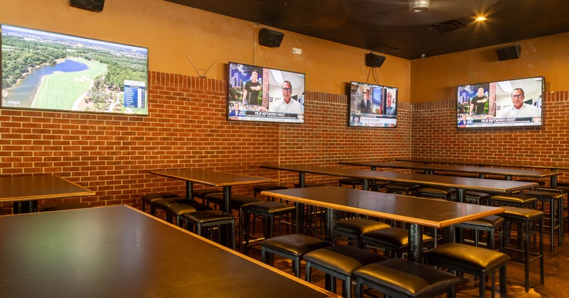 Interior, high seating area, high, tables with stools for six, tv sets on the walls