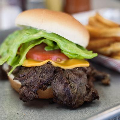 steak sandwich with lettuce, tomato, mayonnaise, and cheese.