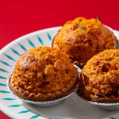 Mini crawfish pies on patterned white plate.