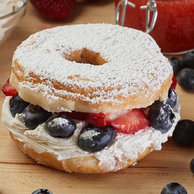 Strawberry and blueberry parfait donut dusted with powdered sugar.