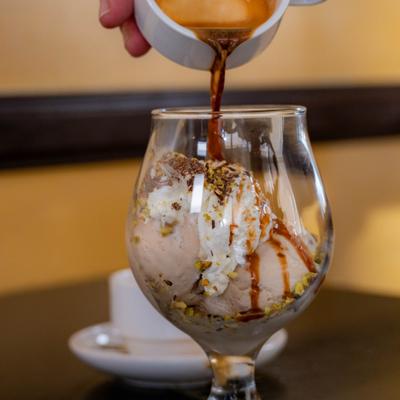 Affogato dessert featuring a shot of espresso poured over ice cream.