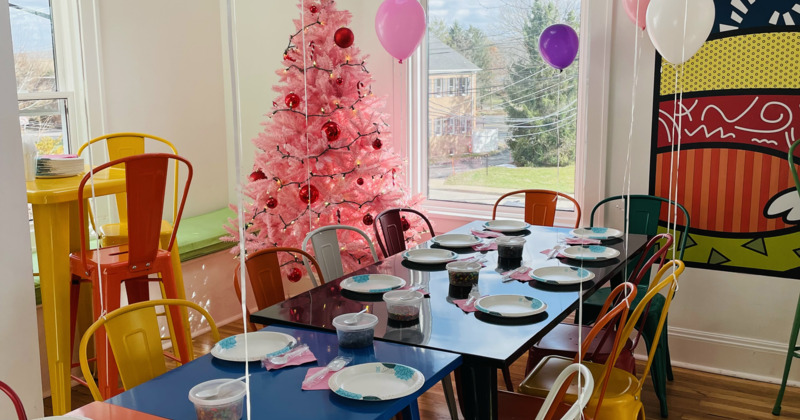 Interior, seating area with different-colored table and chairs, pop art artworks on walls