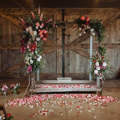 A wooden altar with flowers and flower petals on the ground.