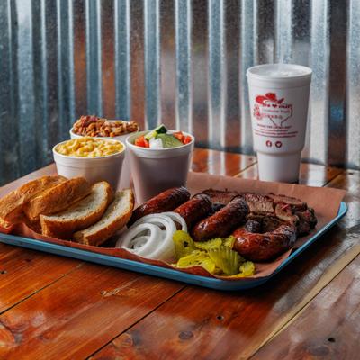 Combo platter, with beef brisket, sausages, vegetable salad, beans, and mac and cheese, and bread.