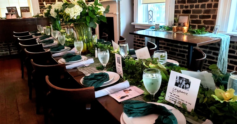 An elegant dinner table setup with green napkins and floral decorations