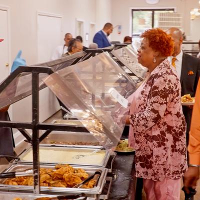 People waiting in line at the food counter.