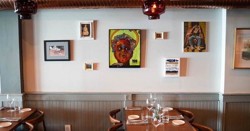 Dining table ready for guests, paintings on the wall