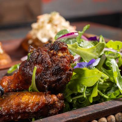 Crispy glazed chicken wings served with mixed greens and edible flowers.