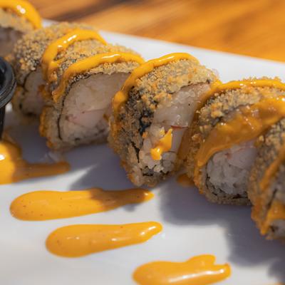 Mexican sushi rolls with shrimp, crab meat, and orange sauce drizzle.