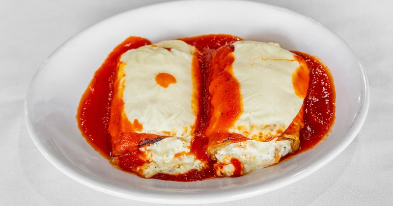 Eggplant Rollatini in marinara sauce, topped with melted mazzarella
