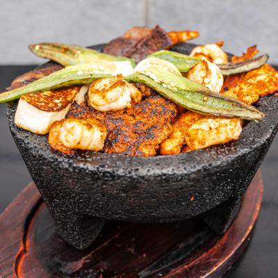 Molcajete featuring carne asada), chicken, chorizo, shrimp, and cactus.