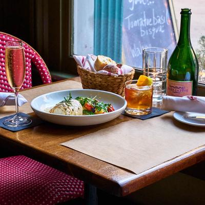 Wahoo fish filet plate served with, bread, a cocktail and wine.