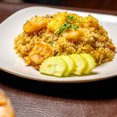 Pineapple fried rice with shrimp and cucamber slices.