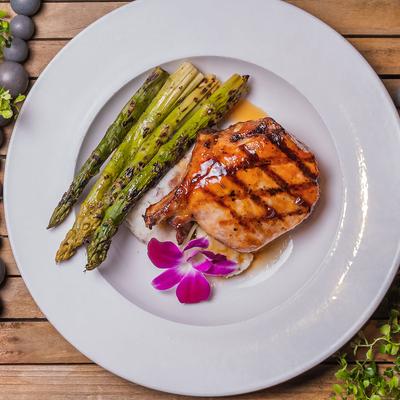 Bone-In French Cut Pork Chop with mashed potatoes and grilled asparagus