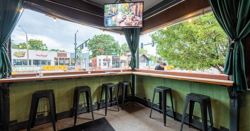 Covered patio, counter seating, TV, and view of the street outside