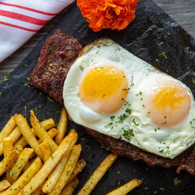 Grilled meat, fried eggs and fries on the side