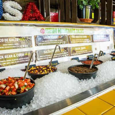 A self-serve bar offering various types of freshly made salsas.