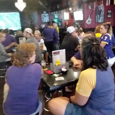 Purple and yellow, fans sitting at the table