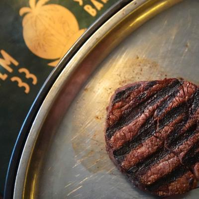 Filet steak with grill marks on metal plate.