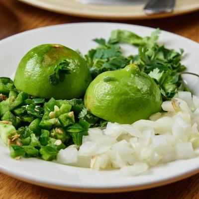 Plate of chopped cilantro and onion with two halfes of lime.