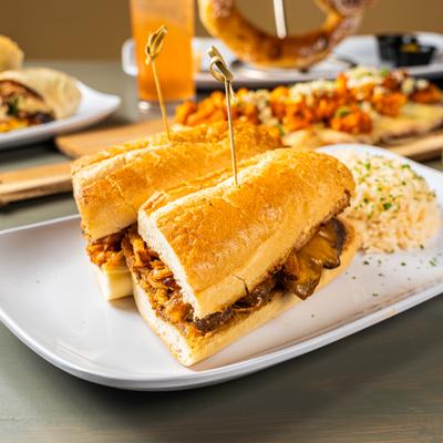 Cheddar and onion steak sandwich served with rice.