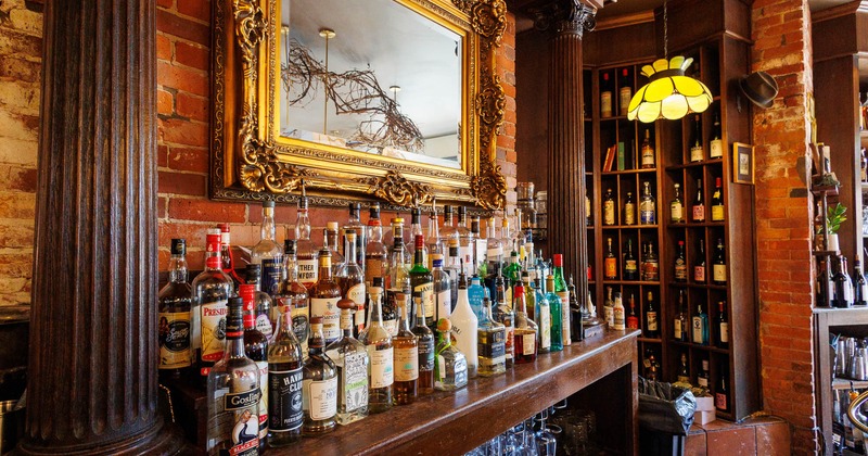 Bar scene with exposed brick wall, featuring beer taps and stacked glasses on shelves
