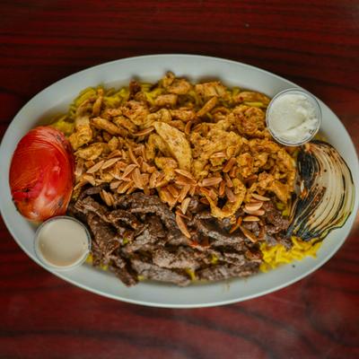 Mixed shawarma with dipping sauces on a plate.