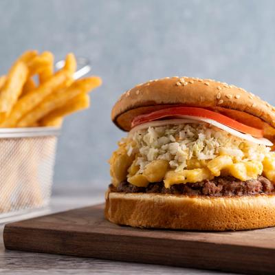 Mac and cheese burger, with blue cheese crumbles, tomato, onion, and fries.