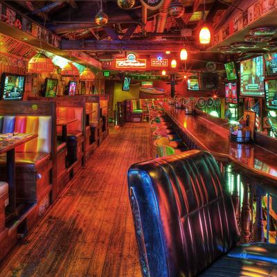 Vibrant bar interior with  colorful booths, and  a bar with high stools