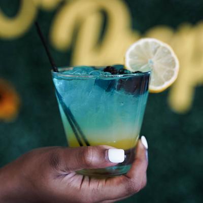 Ocean View Ocean Blue cocktail with blackberries and lemon slice garnish.