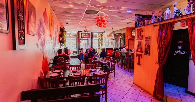 Interior space, dining area with set tables and guests enjoying their food and drinks