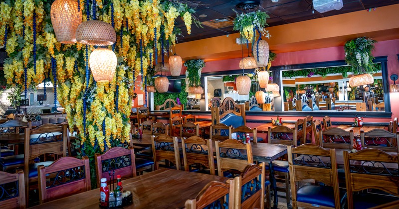Colorfully decorated restaurant dining room with wooden tables, carved chairs