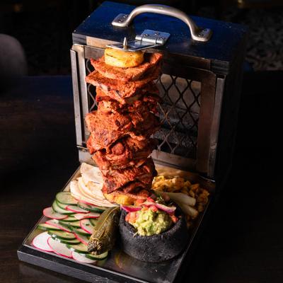 Marinated pork, pineapple, onion, cilantro, lemon, sauces, and tortillas.