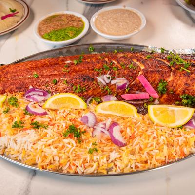 Baked salmon over saffron rice with red onions and lemon slices.