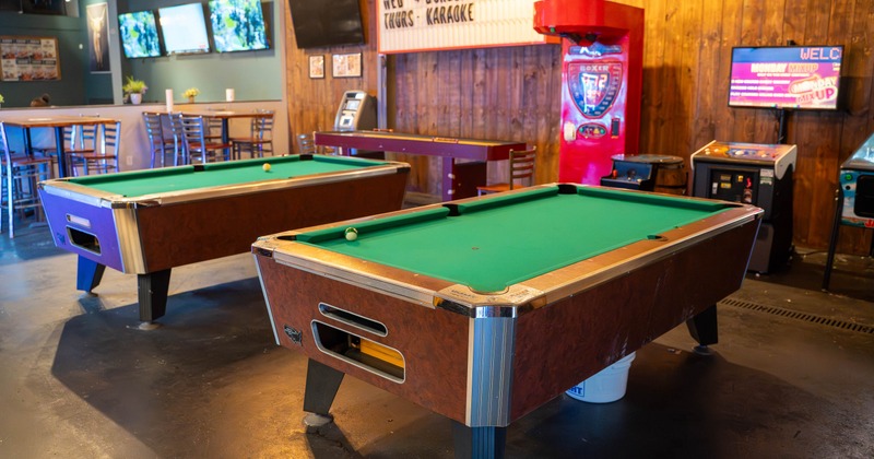 Interior, two pool tables with seating place behind