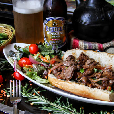 Pulled meat sandwich with a salad and a beer