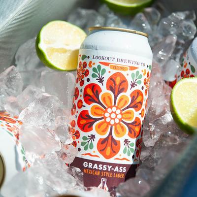 Can of  Mexican-style lager on ice with lime wedges.
