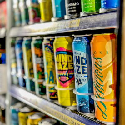 Display of canned beverages in a refrigerated shelf setting.