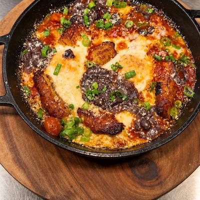 Baked eggs a la cubana: baked eggs, sweet plantains, sofrito, cheese and frijoles.