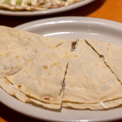 Quesadilla cut into triangular slices, close-up.