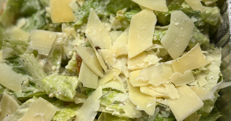 Caesar salad topped with shaved Parmesan