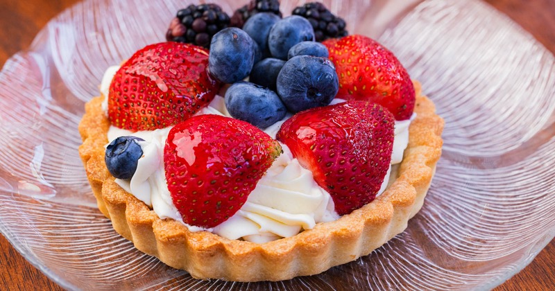A tart topped with a variety of fresh berries