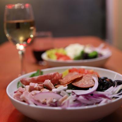 Antipasto salad with ham, pepperoni, salami, tomatoes, red onions, olive, and pepperoncini.