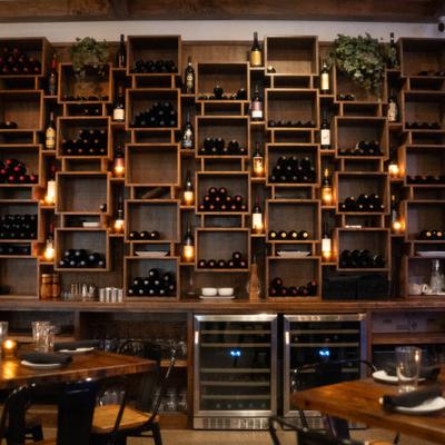 Floor-to-ceiling wooden wine rack with built-in wine refrigerators.