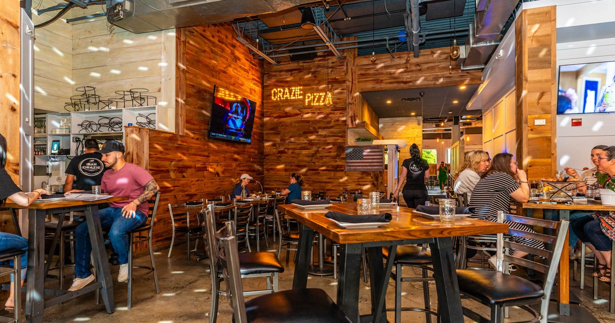 Bar Grazie  interior, wooden walls, TV,  dining tables with seated guests