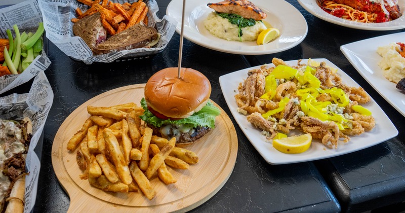 Burger with a side of fries served alongside other dishes