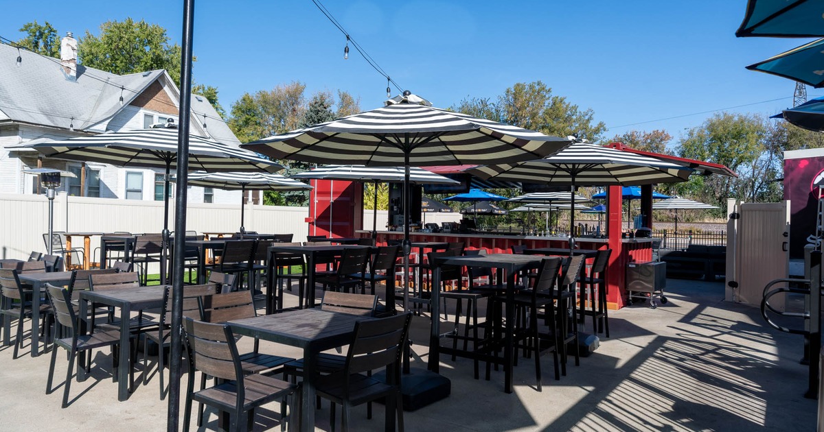 Exterior, outdoor bar, regular and high seating tables with parasols, lanterns